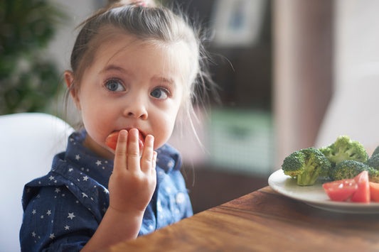 niña comiendo tomate