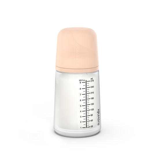 Un Suavinex Biberón Anticólicos ZERO ZERO 270ml Flujo Medio (M) con tapa beige muestra las medidas en ml y oz, permitiendo ver el contenido. Ideal para maridar con productos para bebés con entrega en Mallorca para máxima comodidad.