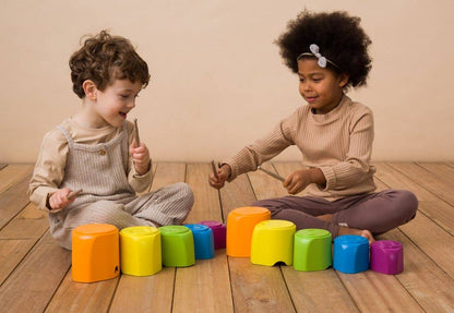 niños jugando con cubos tocando tambor