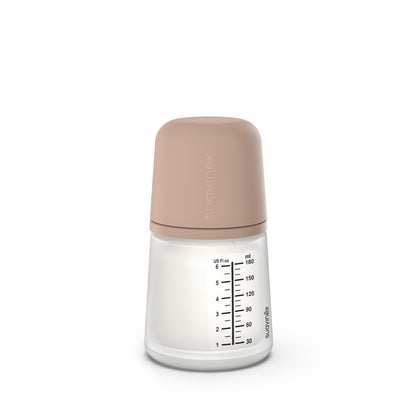 El Biberón Anticólicos ZERO ZERO 180 ml +0m Flujo Adaptable(A) de Suavinex ofrece una tapa de color beige, con marcajes de mililitros (hasta 150 ml) y onzas (hasta 5 oz).