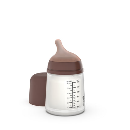 Junto a su tapa se encuentra un biberón anticólicos ZERO ZERO de Suavinex de 180 ml con tapón y tetina de color marrón. El biberón transparente muestra los mililitros y las onzas líquidas estadounidenses. Aprovecha las ofertas en parafarmacia infantil mientras compras todo lo que necesita tu bebé.